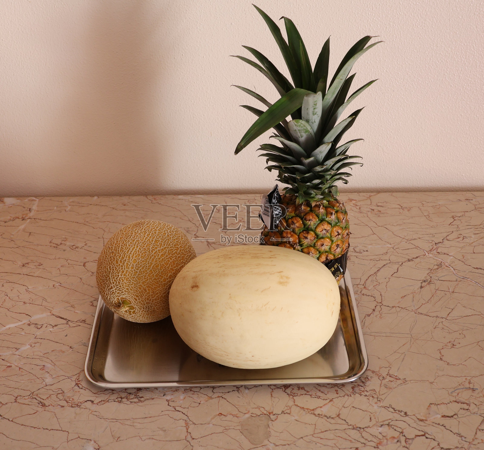 托盘上的菠萝和哈密瓜照片摄影图片