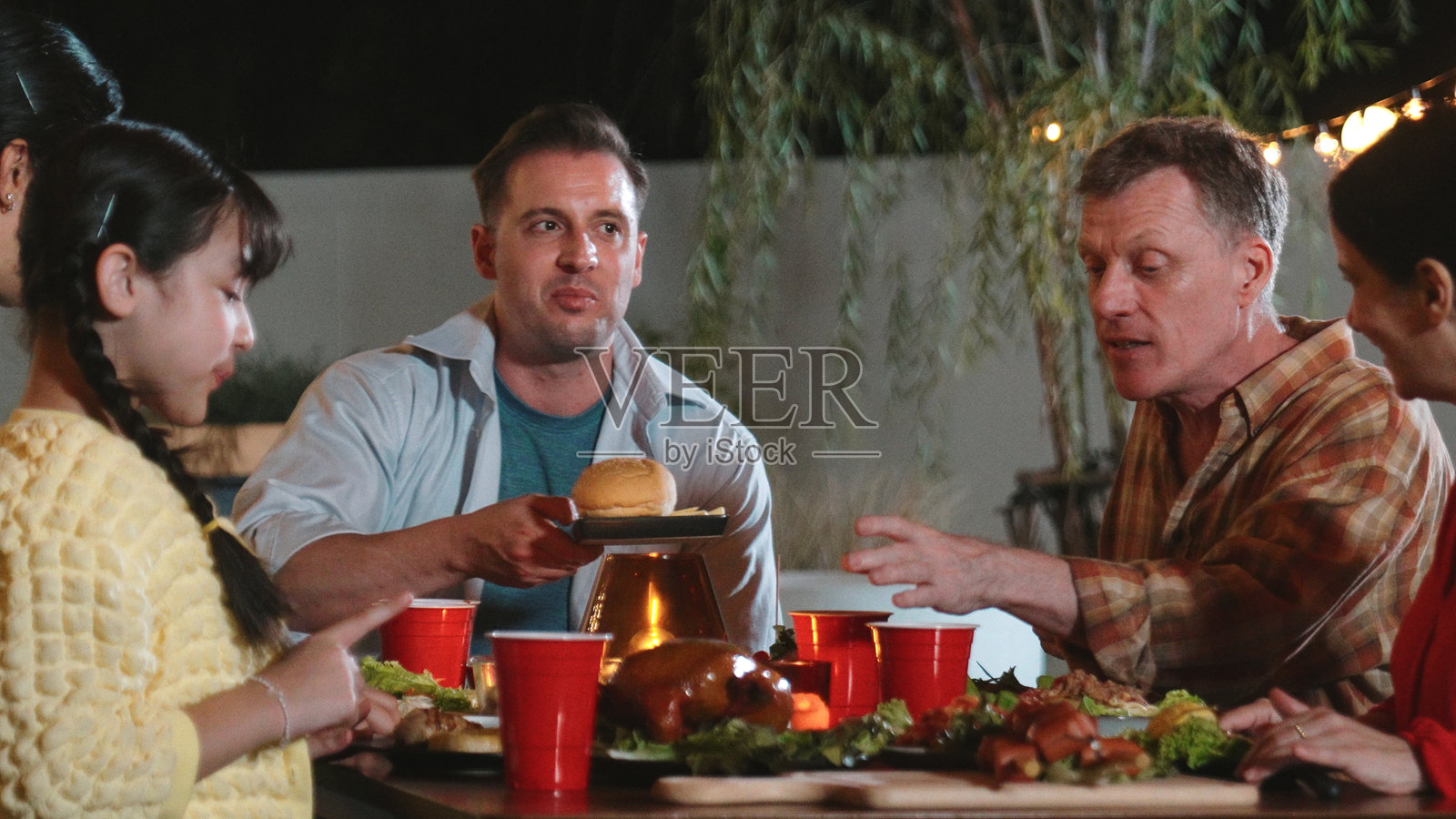 家庭聚在一起庆祝假期,放松并举行晚宴派对。分歧。照片摄影图片