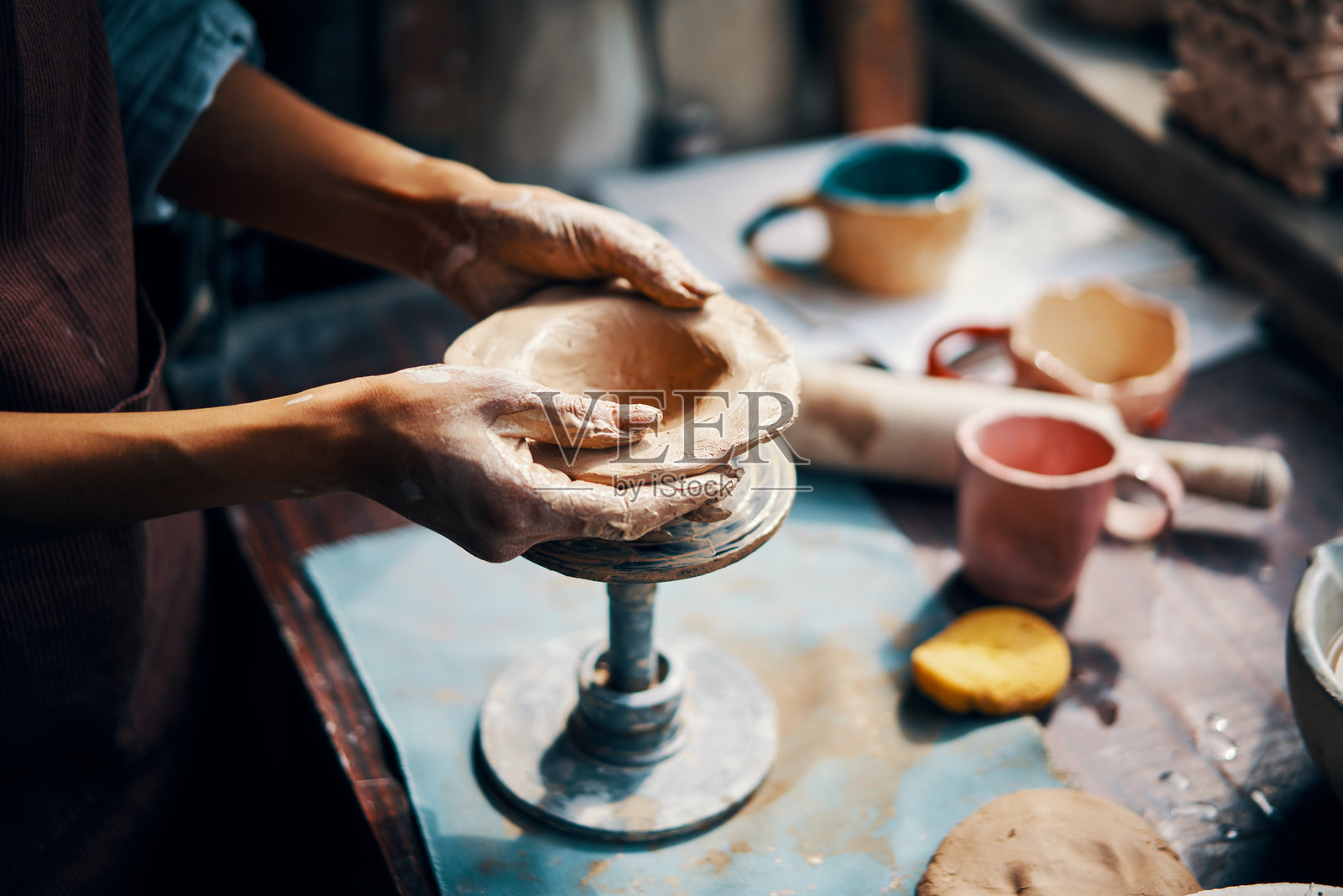 女性艺术家在她的创意工作室用陶土雕刻工艺品照片摄影图片