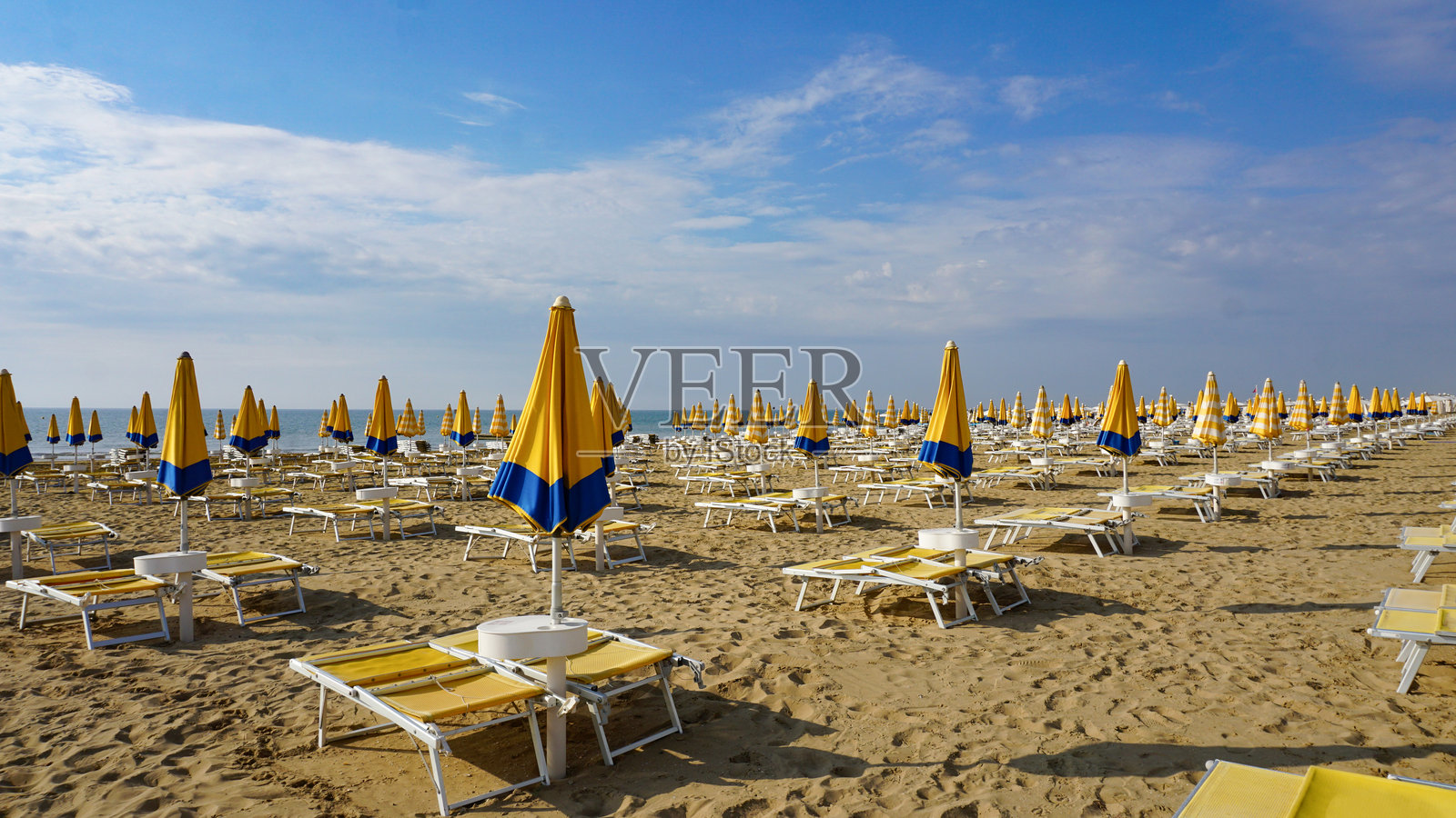 意大利威尼托地区威尼斯附近的杰索罗海滩上的伞。照片摄影图片