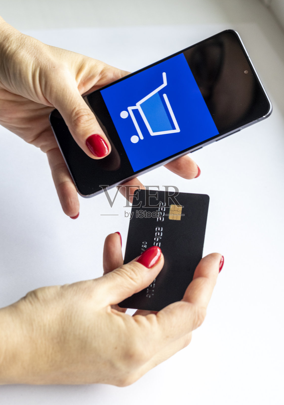 女人拿着信用卡和手机的特写。科技照片摄影图片
