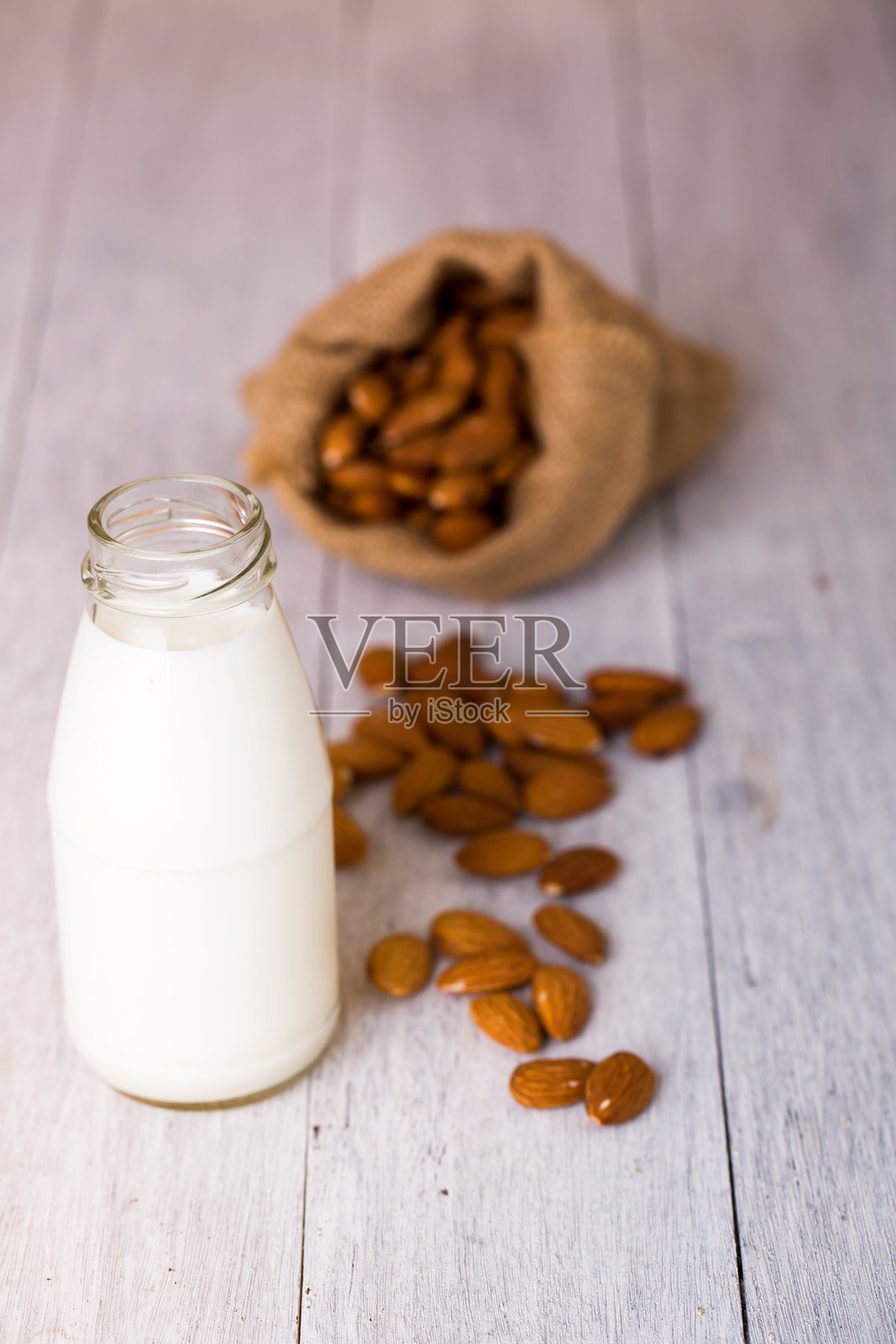 桌子上近距离拍摄的杏仁和牛奶瓶照片摄影图片