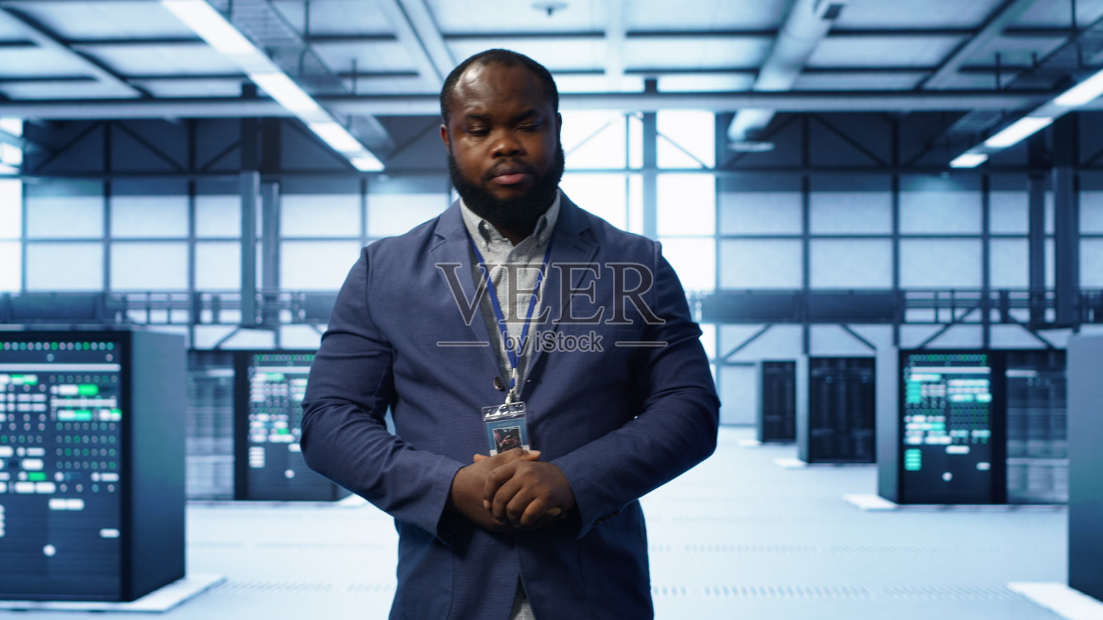 技术人员在数据中心的服务器行间走动,进行检查照片摄影图片