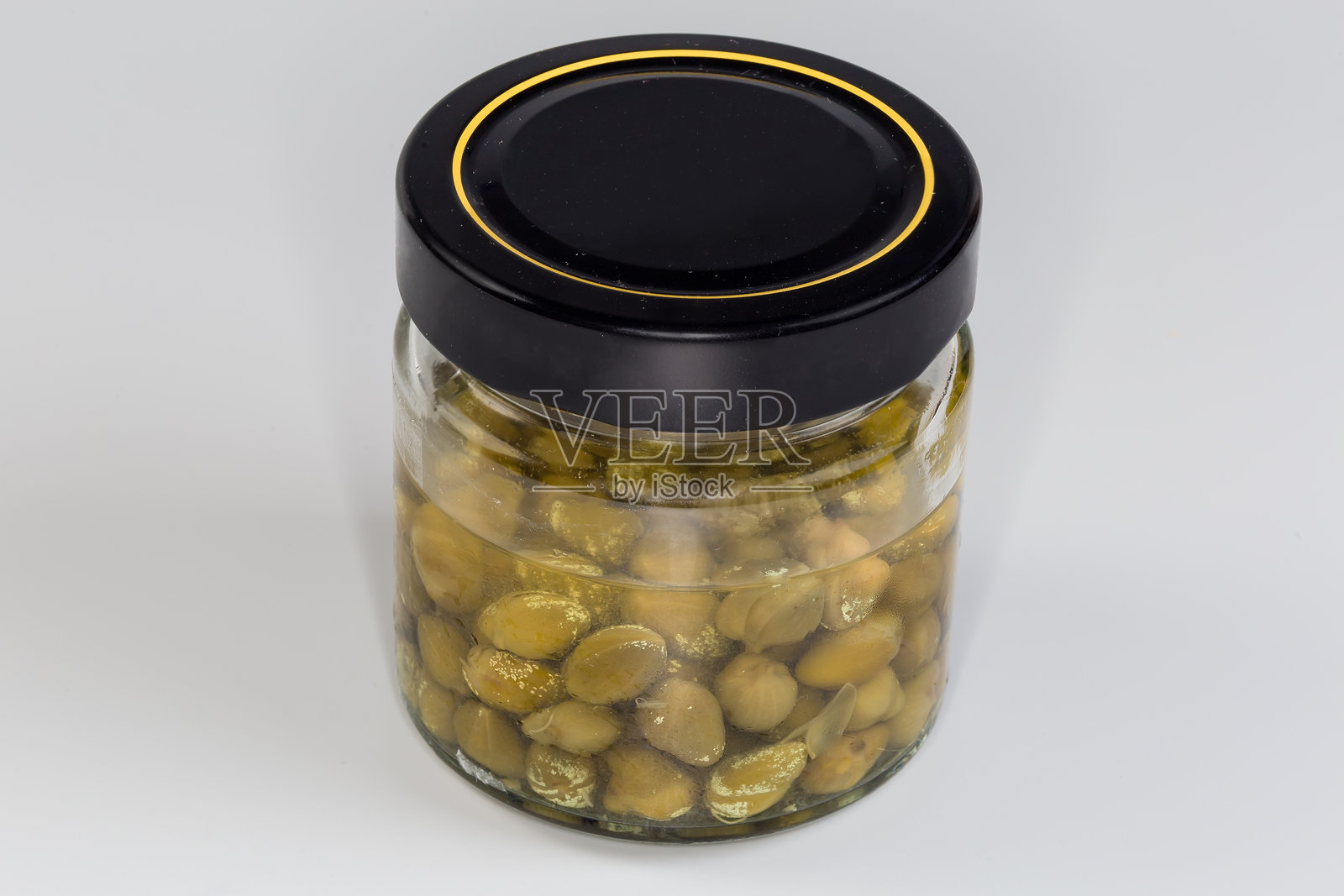 灰色背景上小封闭罐中的腌制刺山柑照片摄影图片