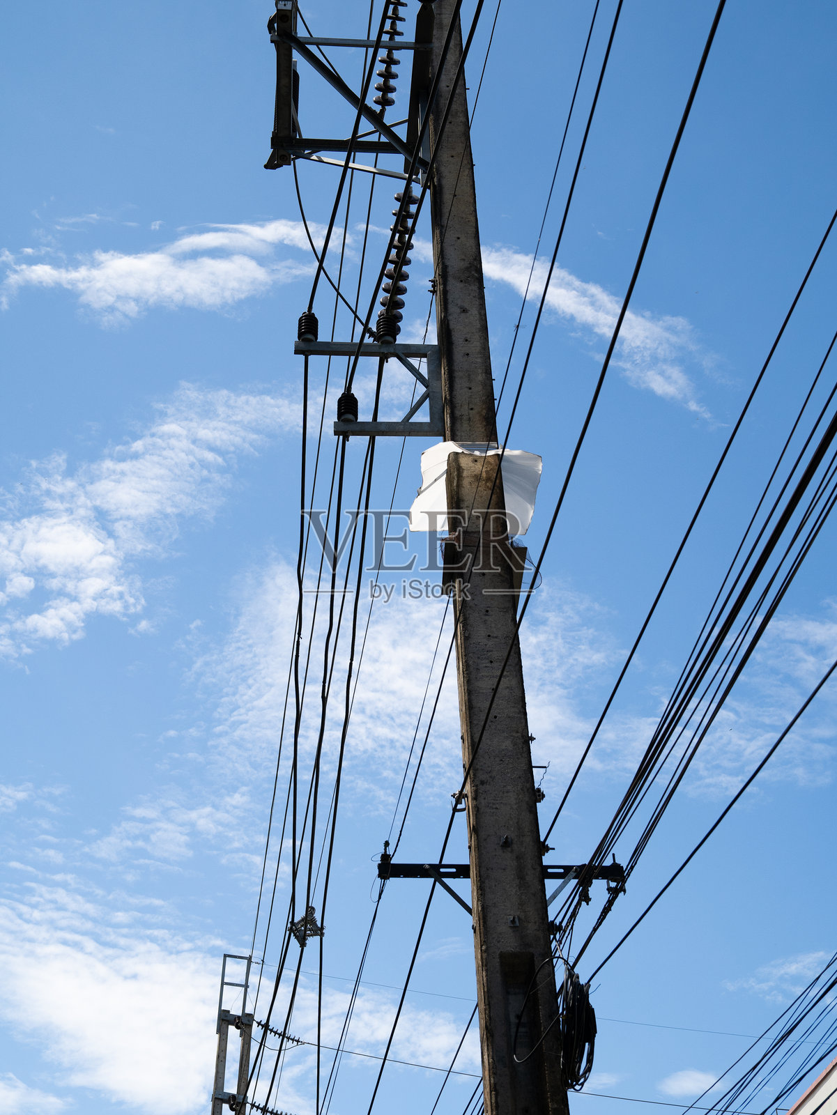 电力线在蓝天中延伸,由高大的钢塔支撑,传输电力和能量,与云朵融为一体。照片摄影图片