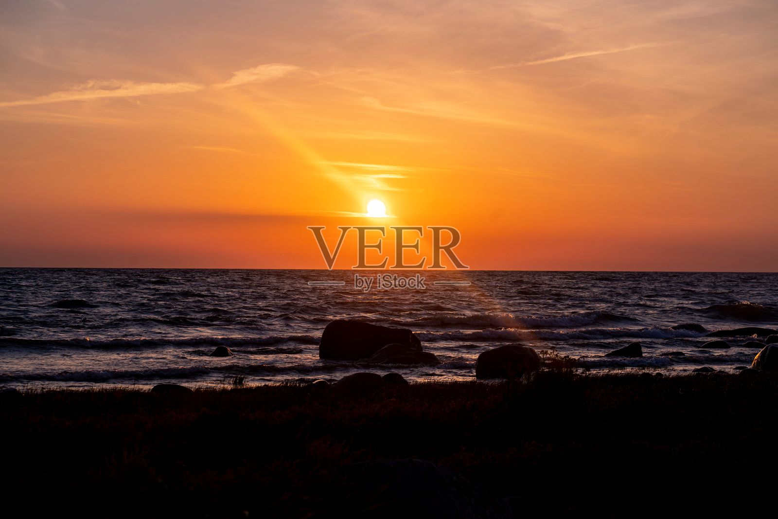 海上日落,剪影般的岩石。照片摄影图片