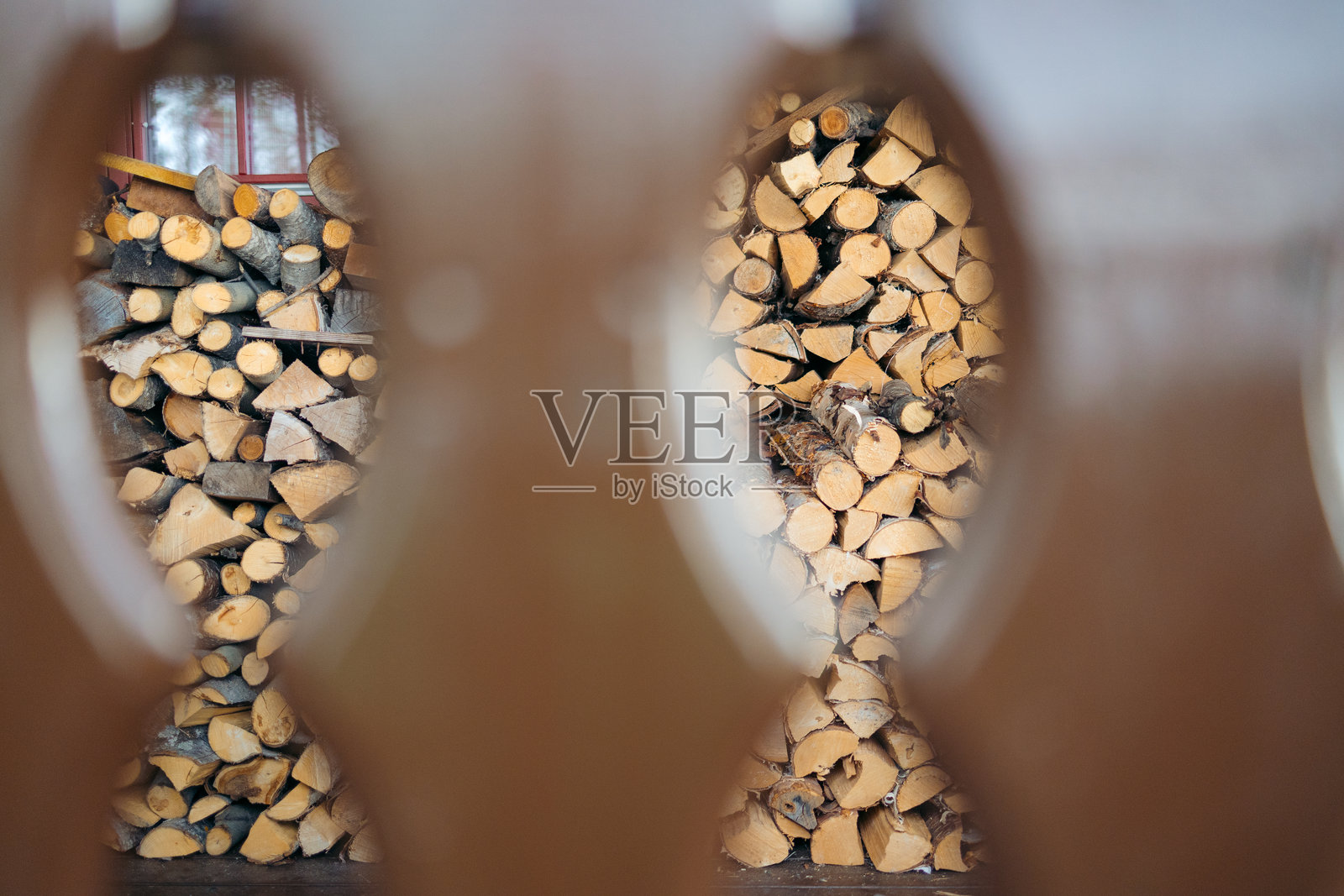 透过木栅栏看到的一堆柴火照片摄影图片