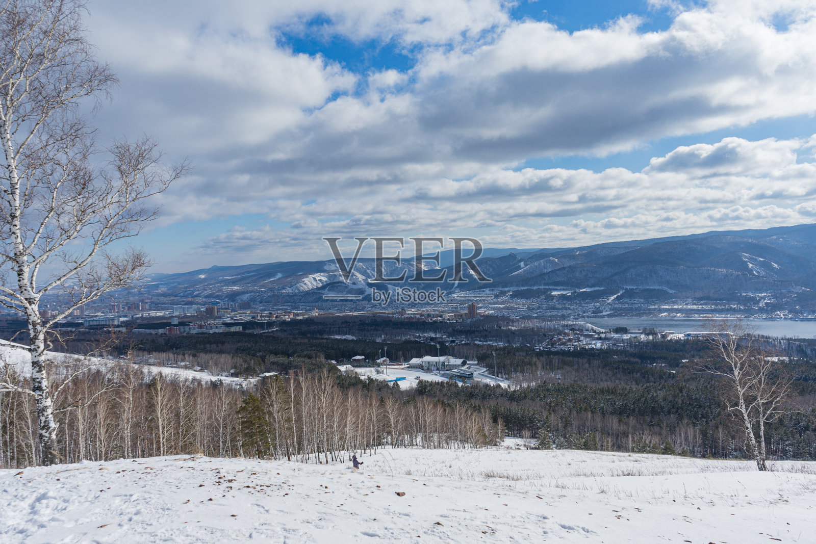 城市与自然的邻里。蓝天上漂浮着低矮的白云。照片摄影图片