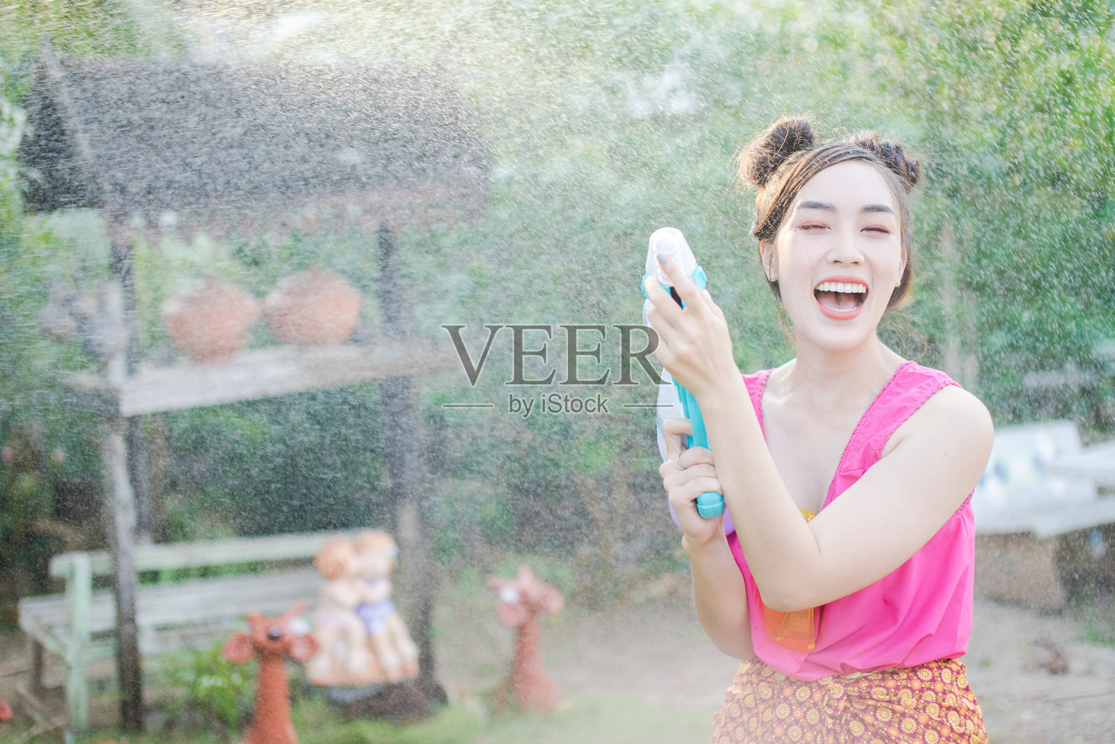 水喷洒在微笑的美丽女性身上照片摄影图片