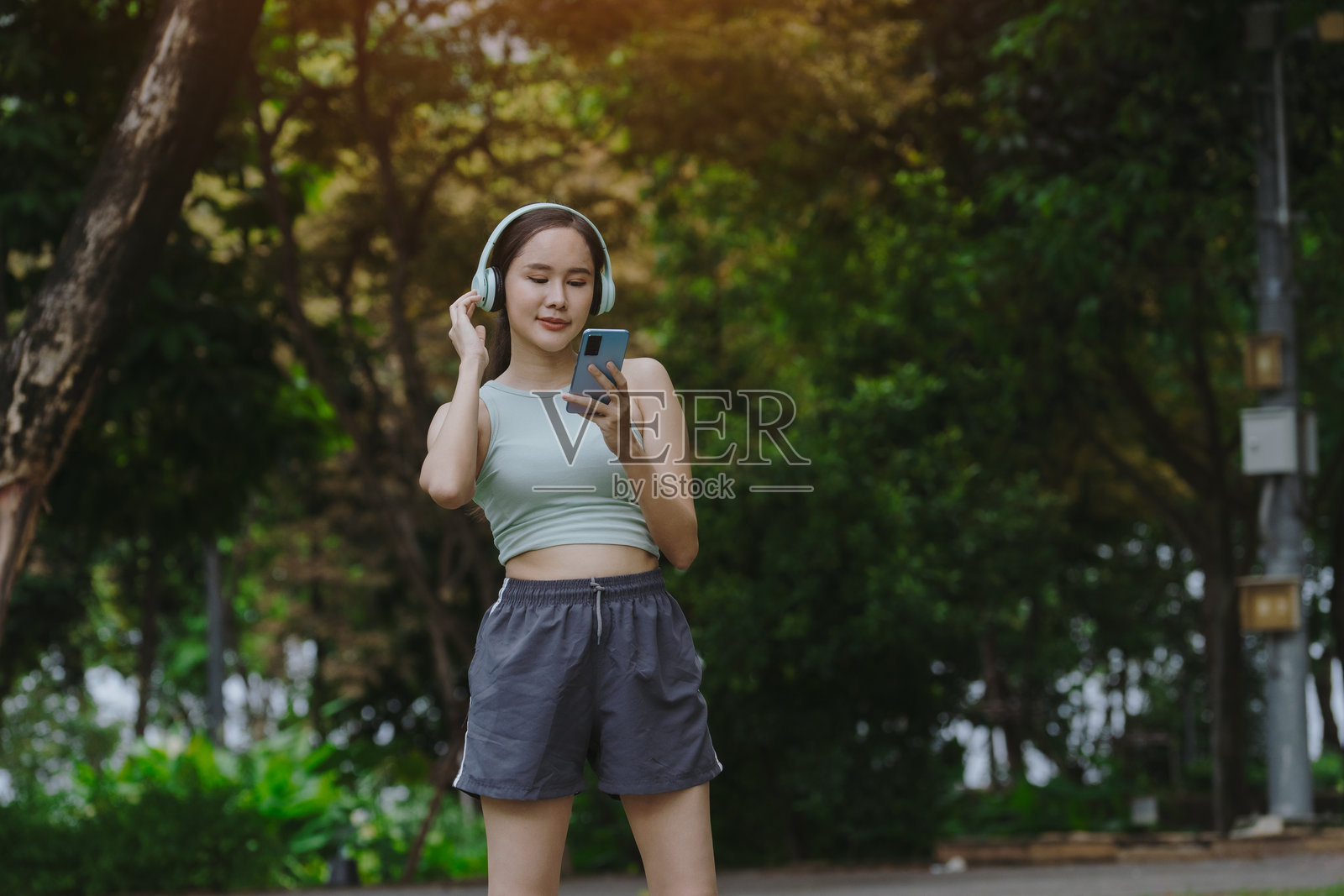 年轻女性在公园锻炼和拉伸。女性在城市公园慢跑和做健身运动。照片摄影图片