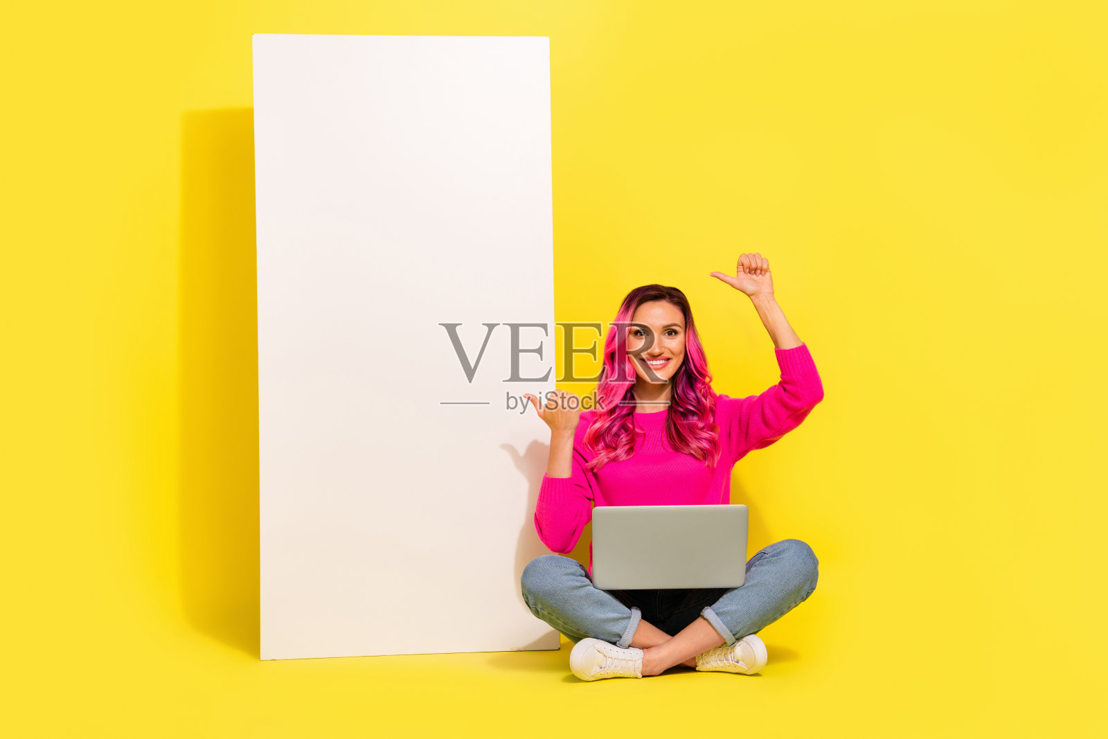 可爱女孩穿着毛衣,手持苹果和三星电子产品,竖起大拇指,背景为黄色,空白空间。照片摄影图片