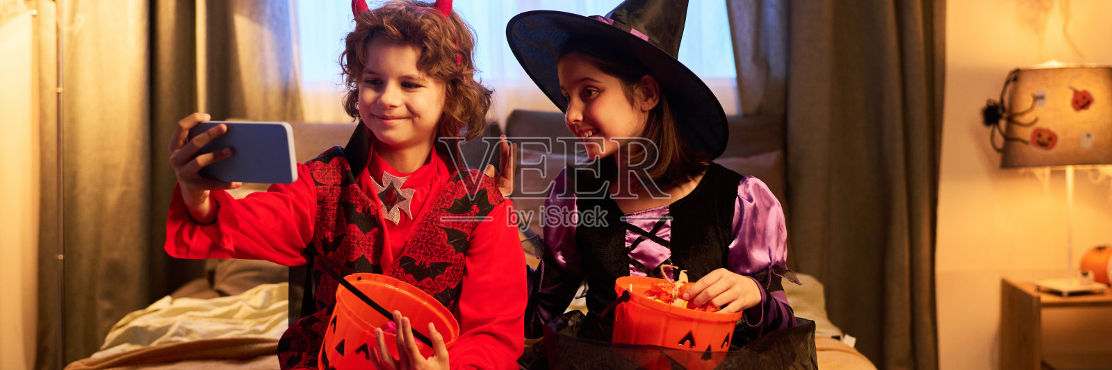 孩子们穿着 costumes 在床上自拍照片摄影图片