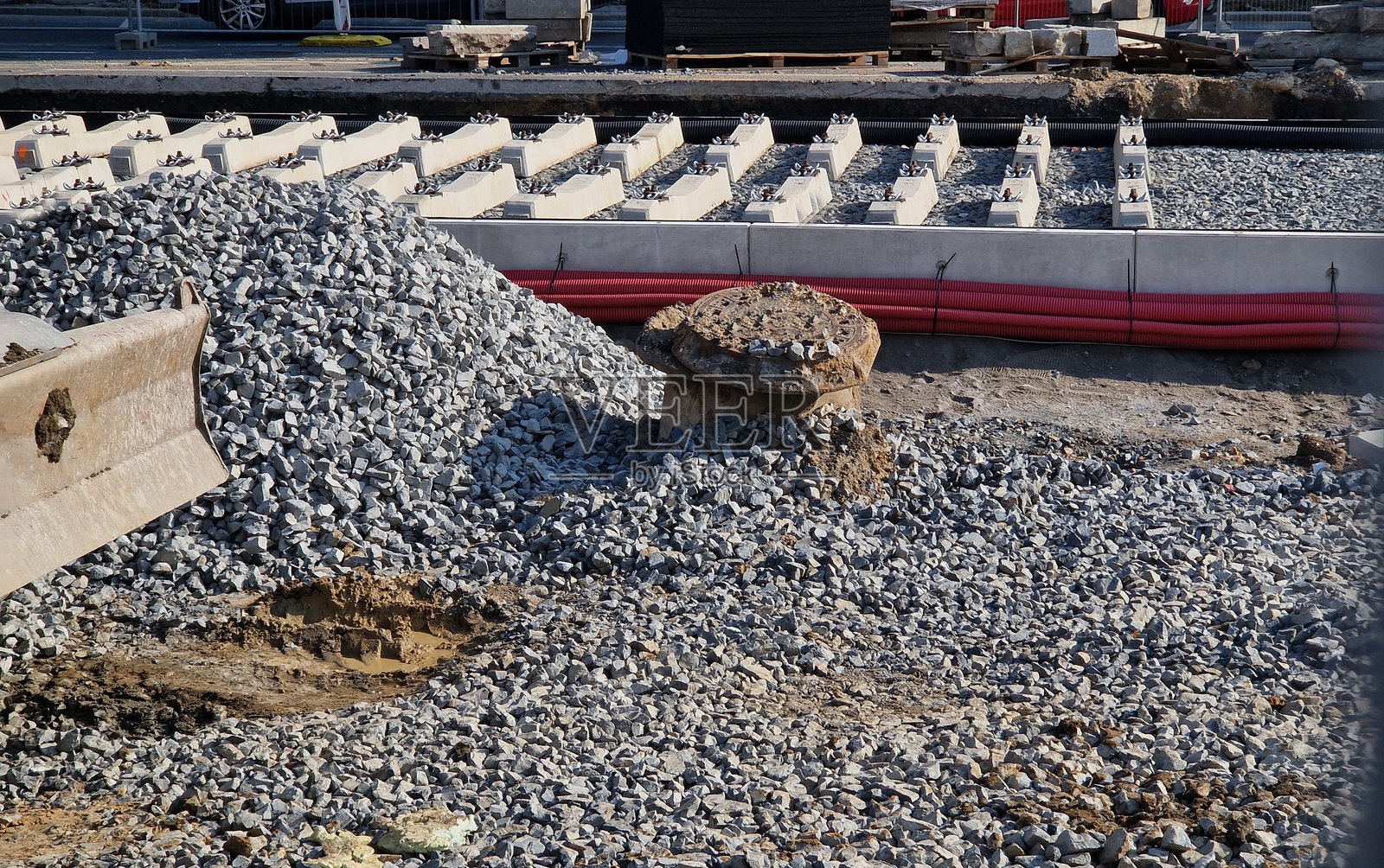 在两条电车轨道交叉口,使用测量设备进行新精确的轨道铺设。铺设一层碎石,上面放置混凝土枕木。由橡胶制成的防震橡胶基础。照片摄影图片
