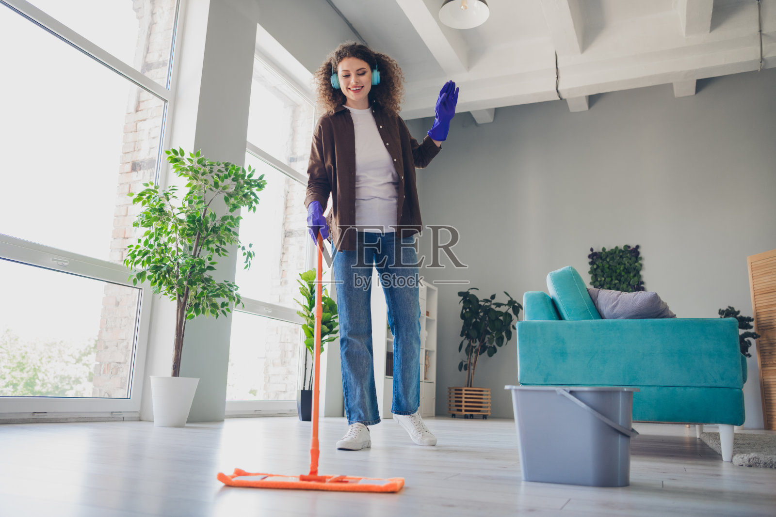 卷发年轻女子在家舒适打扫照片照片摄影图片