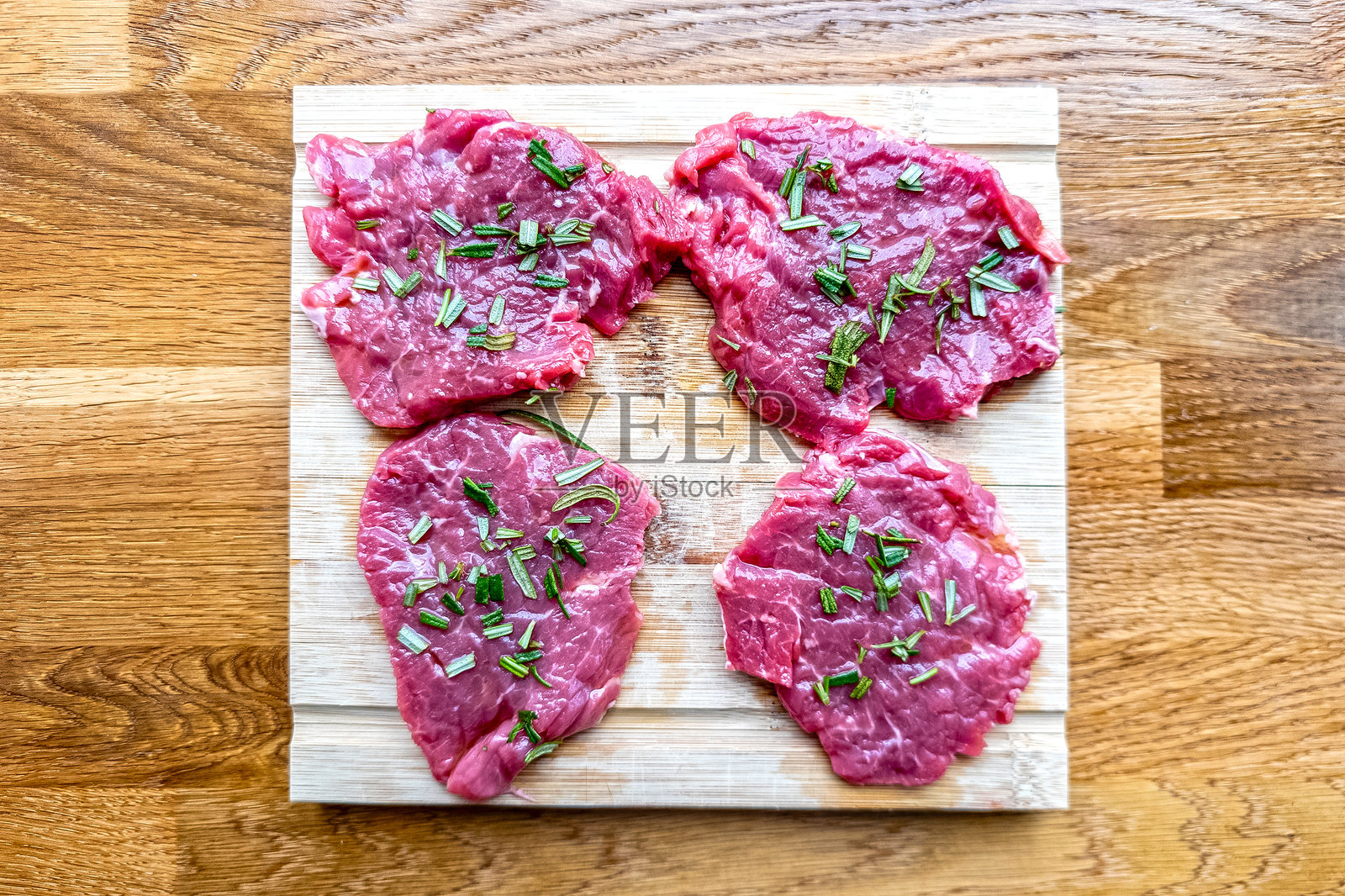 切片生肋眼牛排,配以迷迭香和橄榄油照片摄影图片