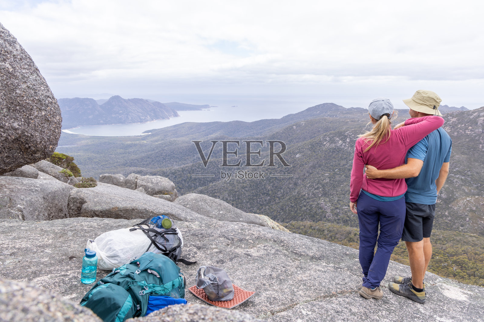 在山顶拥抱的情侣,背景是美丽的风景照片摄影图片