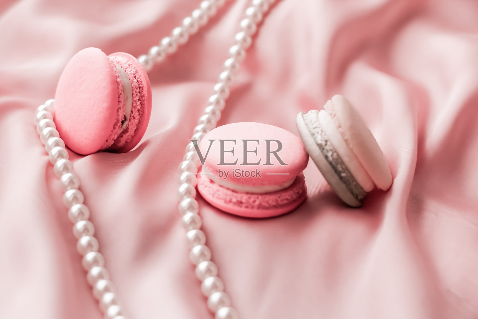 粉色布料上的马卡龙特写照片摄影图片