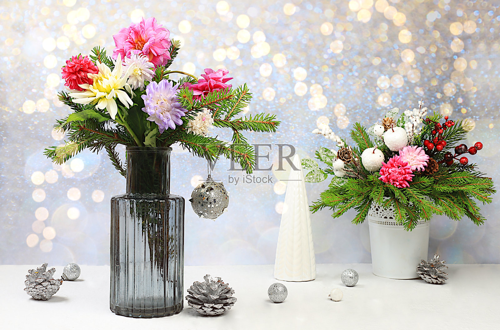 圣诞节创意花束,包含活的冷杉枝条、菊花和自制装饰,放在优雅的节日背景下的花瓶中。适用于设计和产品展示的圣诞和新年生态布局。照片摄影图片