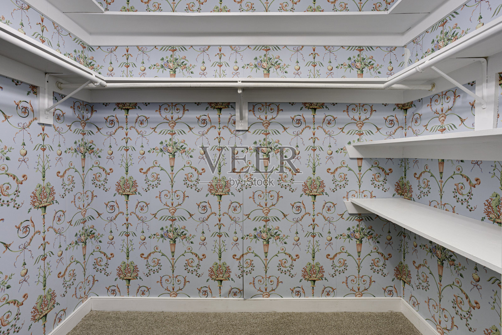 明亮的衣橱内部,配有花卉图案的壁纸。照片摄影图片