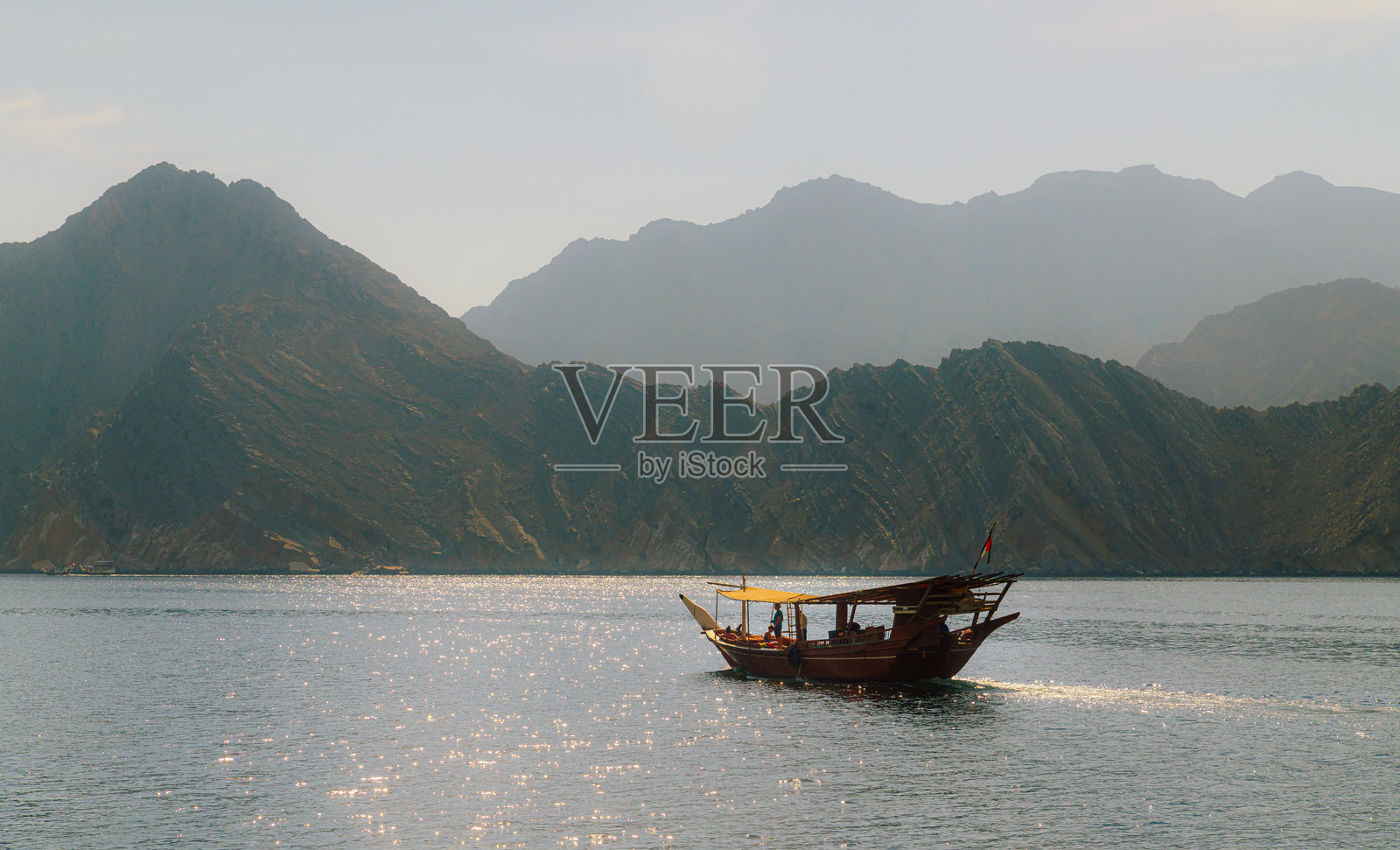 在风景如画的山脉景观中航行的传统船只照片摄影图片