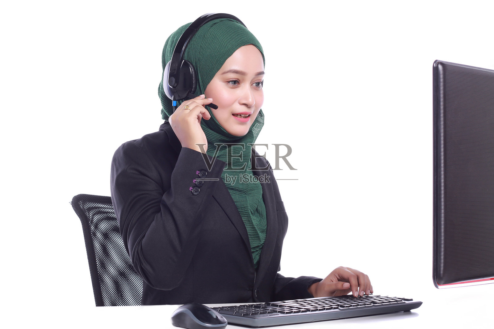 戴着耳机的女商人在白色背景下工作,头戴头巾。照片摄影图片