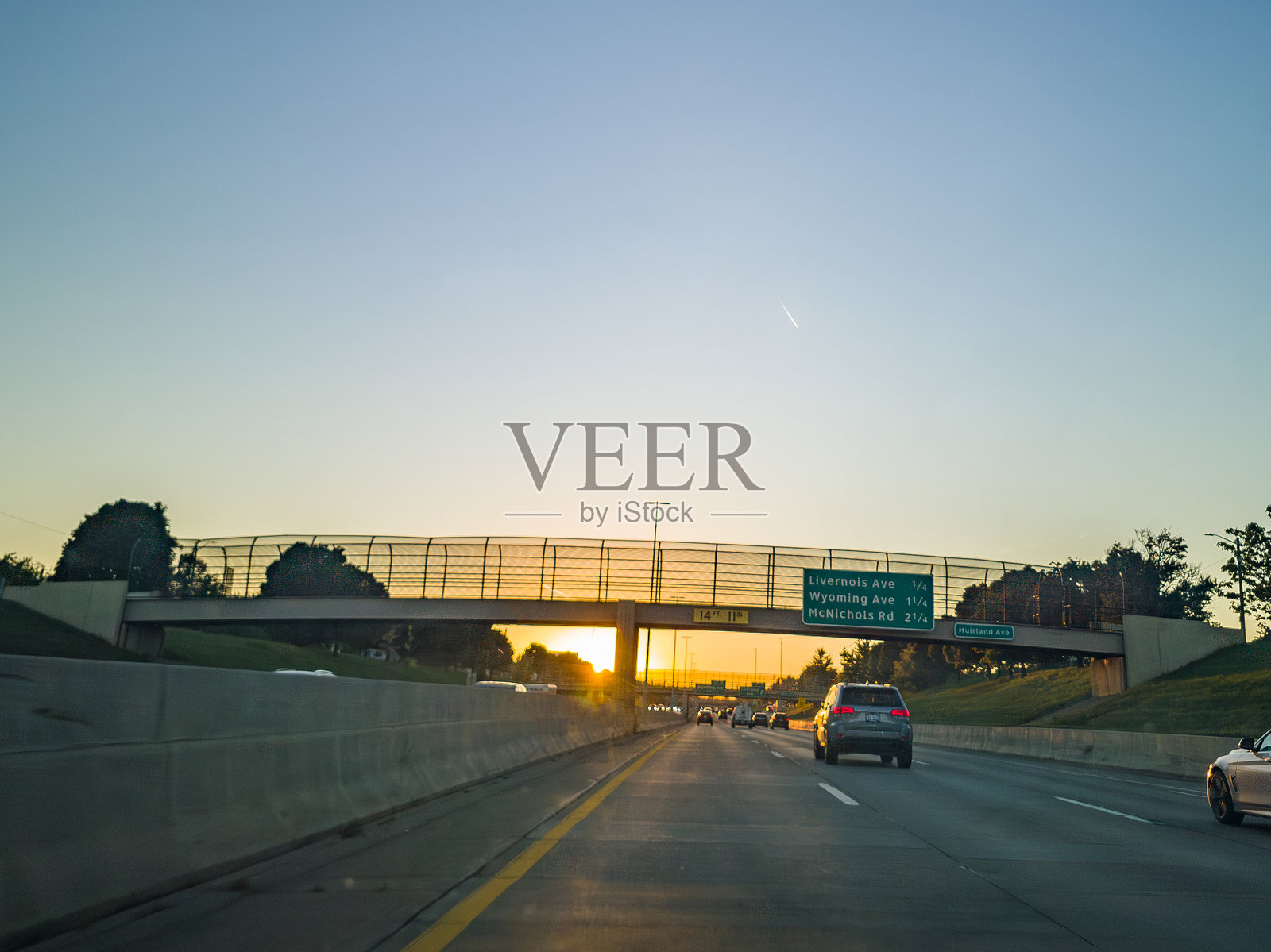 位于密歇根州底特律M-10洛奇高速公路的穆尔兰大道上的人行天桥背后的日落照片摄影图片