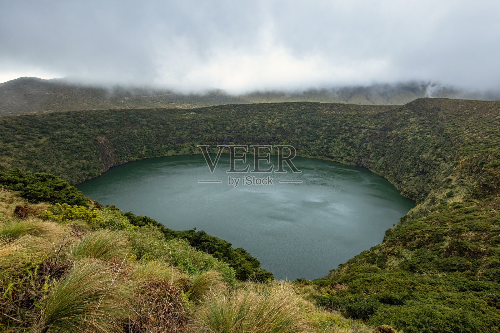 白云在葡萄牙亚速尔群岛的弗洛雷斯岛山湖上盘旋照片摄影图片