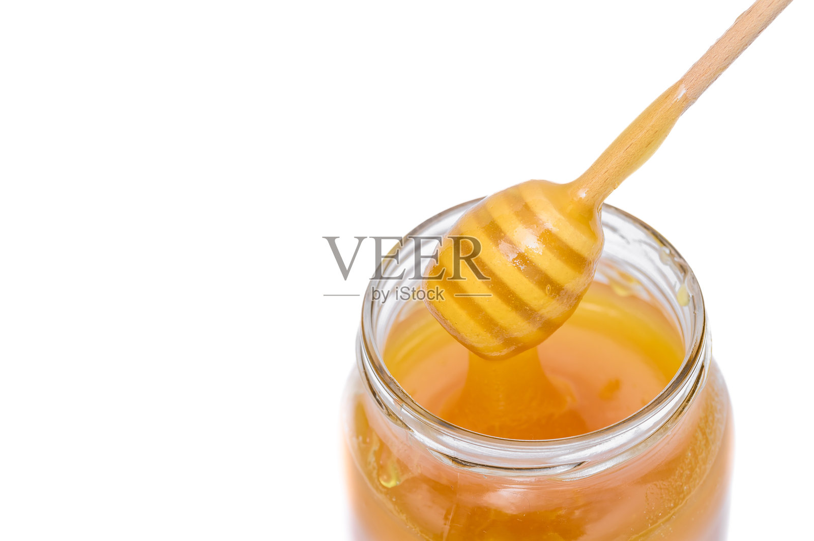 白色背景下的透明瓶装液态石灰蜂蜜照片摄影图片