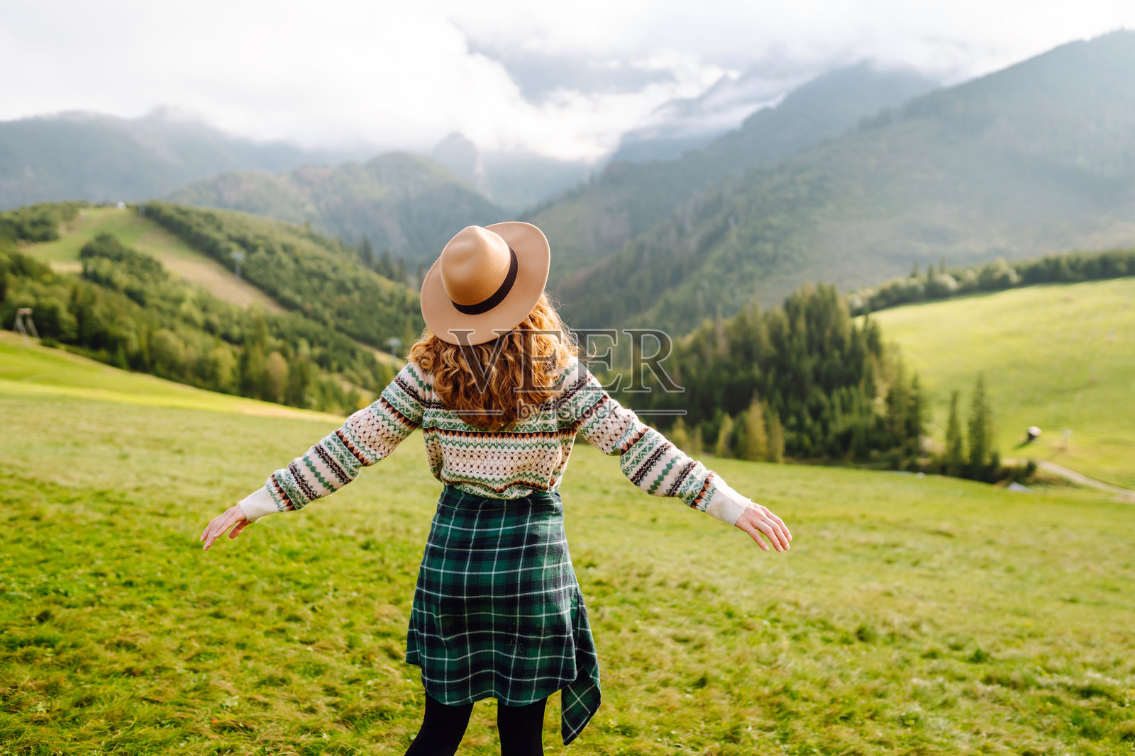 快乐的女性游客欣赏山脉自然风光。照片摄影图片