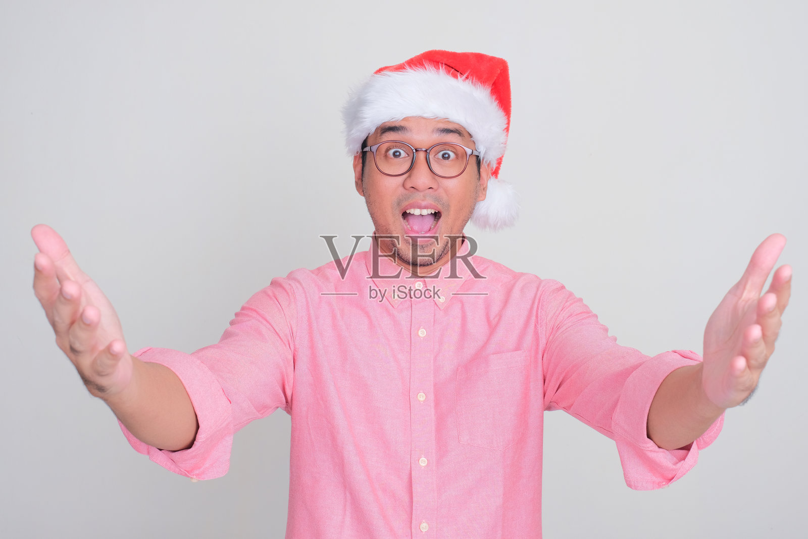 一个戴着圣诞帽的男人露出惊讶的表情照片摄影图片