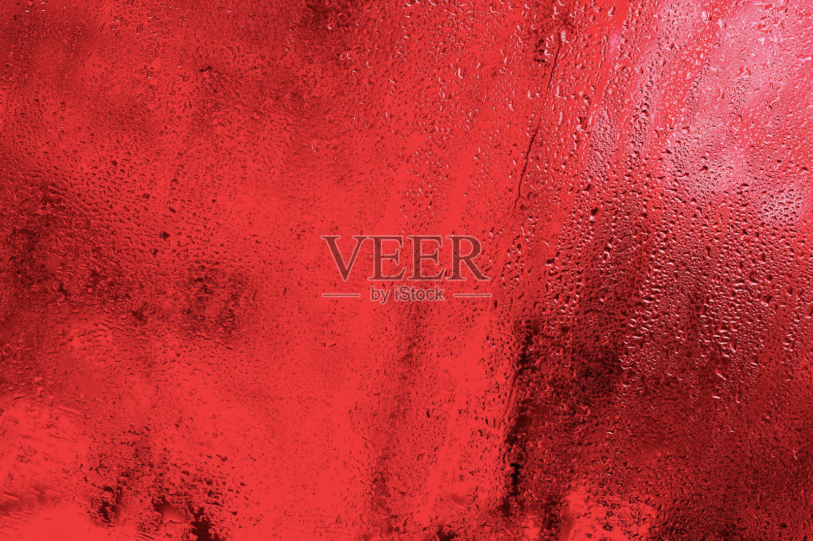 湿润的玻璃,水滴沿着玻璃滑落,红色背景。照片摄影图片