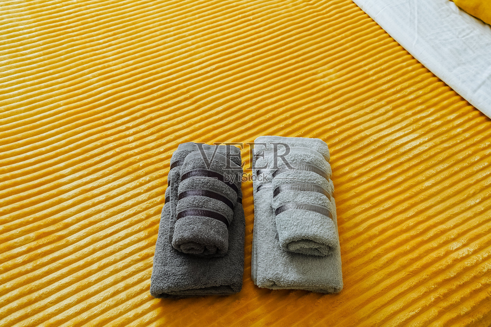 新鲜的毛巾整齐地叠放在床上,随时准备迎接一场焕发活力的淋浴,增添了房间的温馨感。它们的柔软和舒适提升了放松的氛围。照片摄影图片