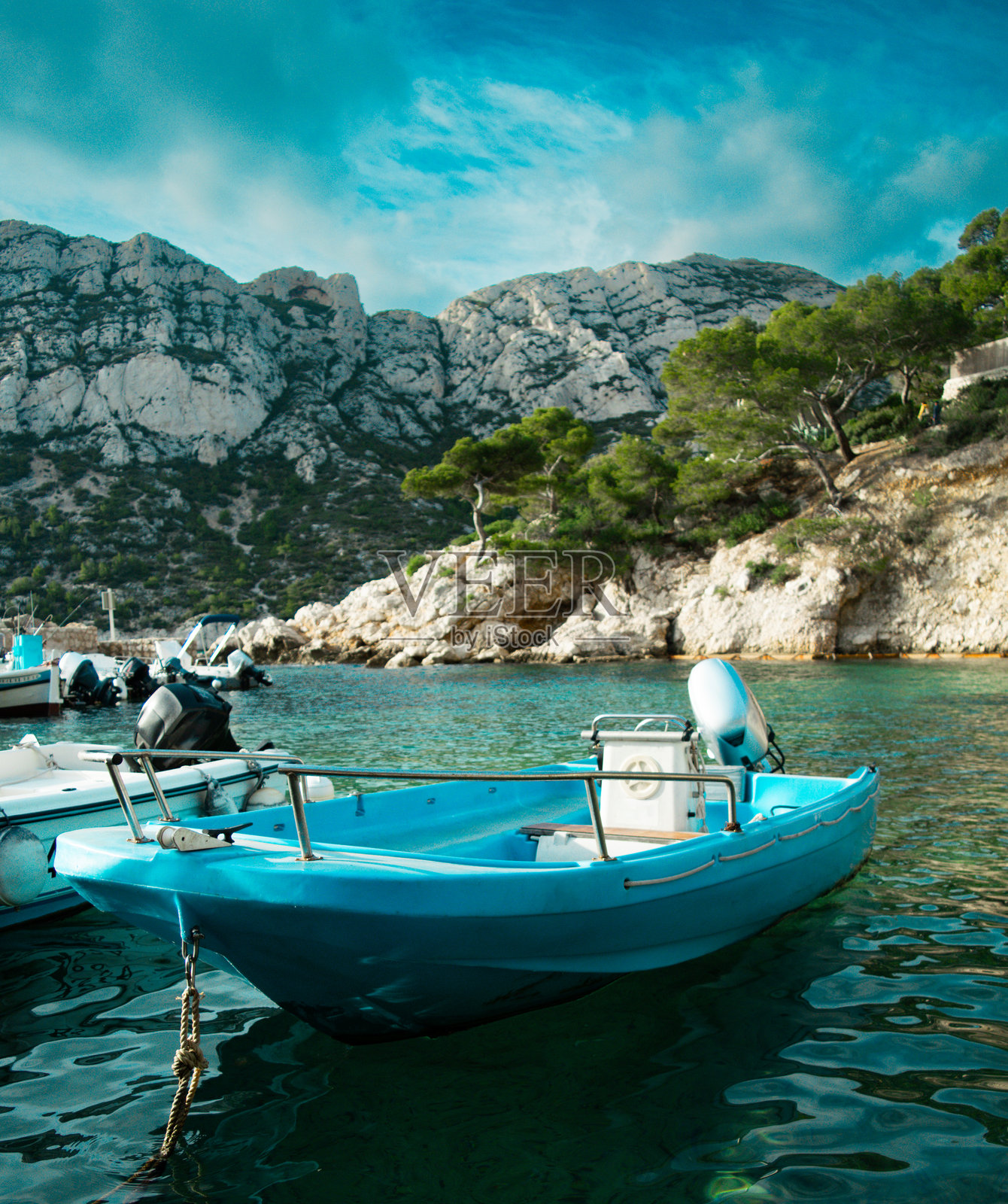 现代动力船在水面上,背景是明亮的黑暗天空和岩石地形。照片摄影图片