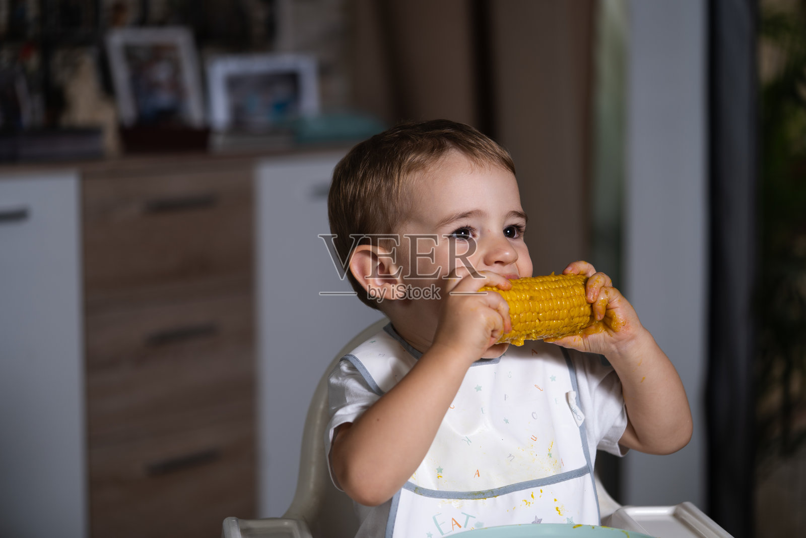 孩子在吃玉米棒照片摄影图片