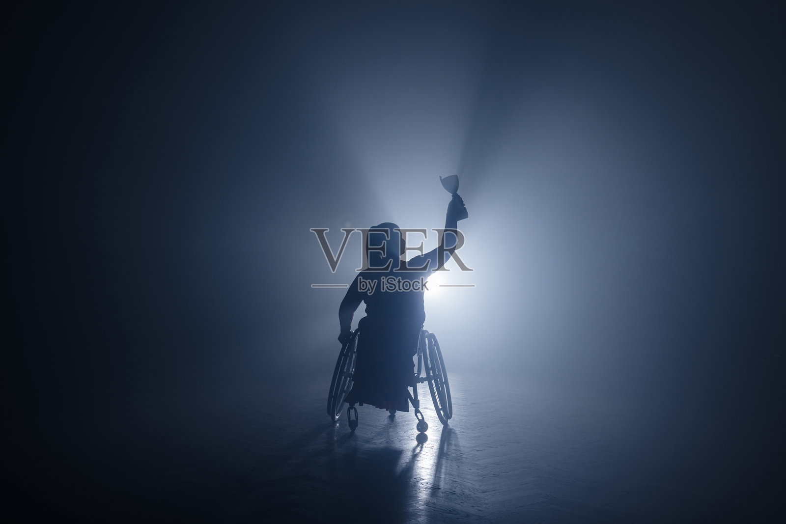 一位身体残疾的女性高举奖杯庆祝体育胜利照片摄影图片