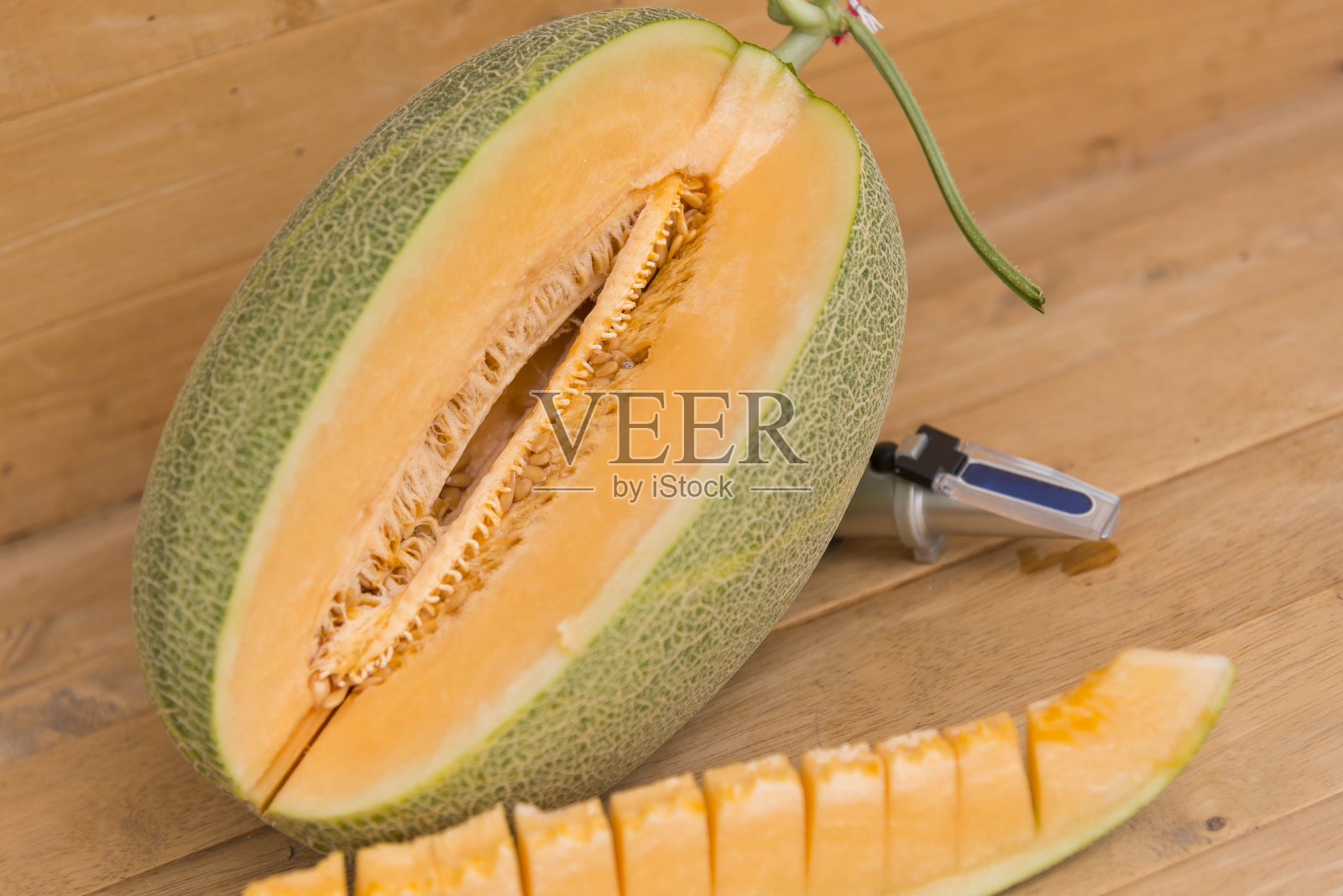 将橙色哈密瓜切开放在木盘上照片摄影图片