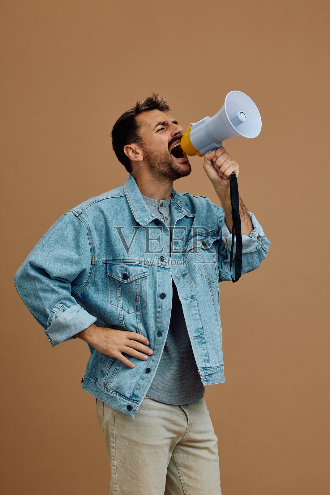 一个男人通过扩音器大喊的工作室拍摄。照片摄影图片