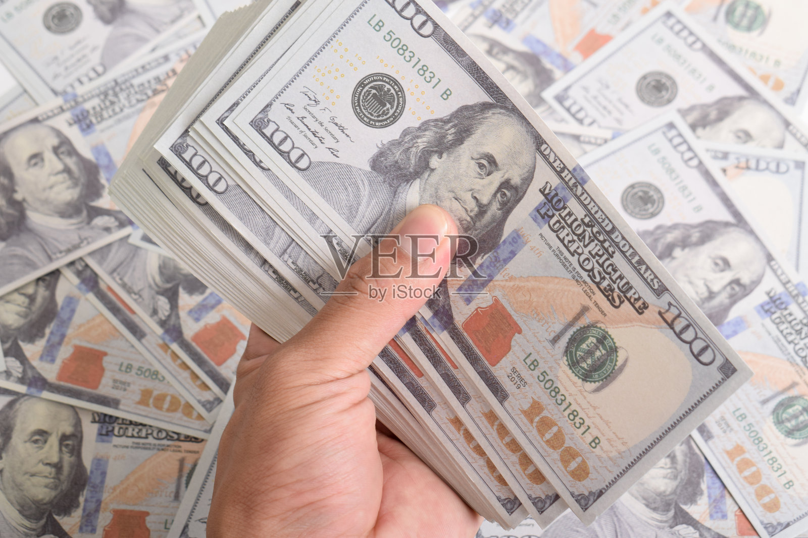 男人的手握着一百美元钞票。照片摄影图片