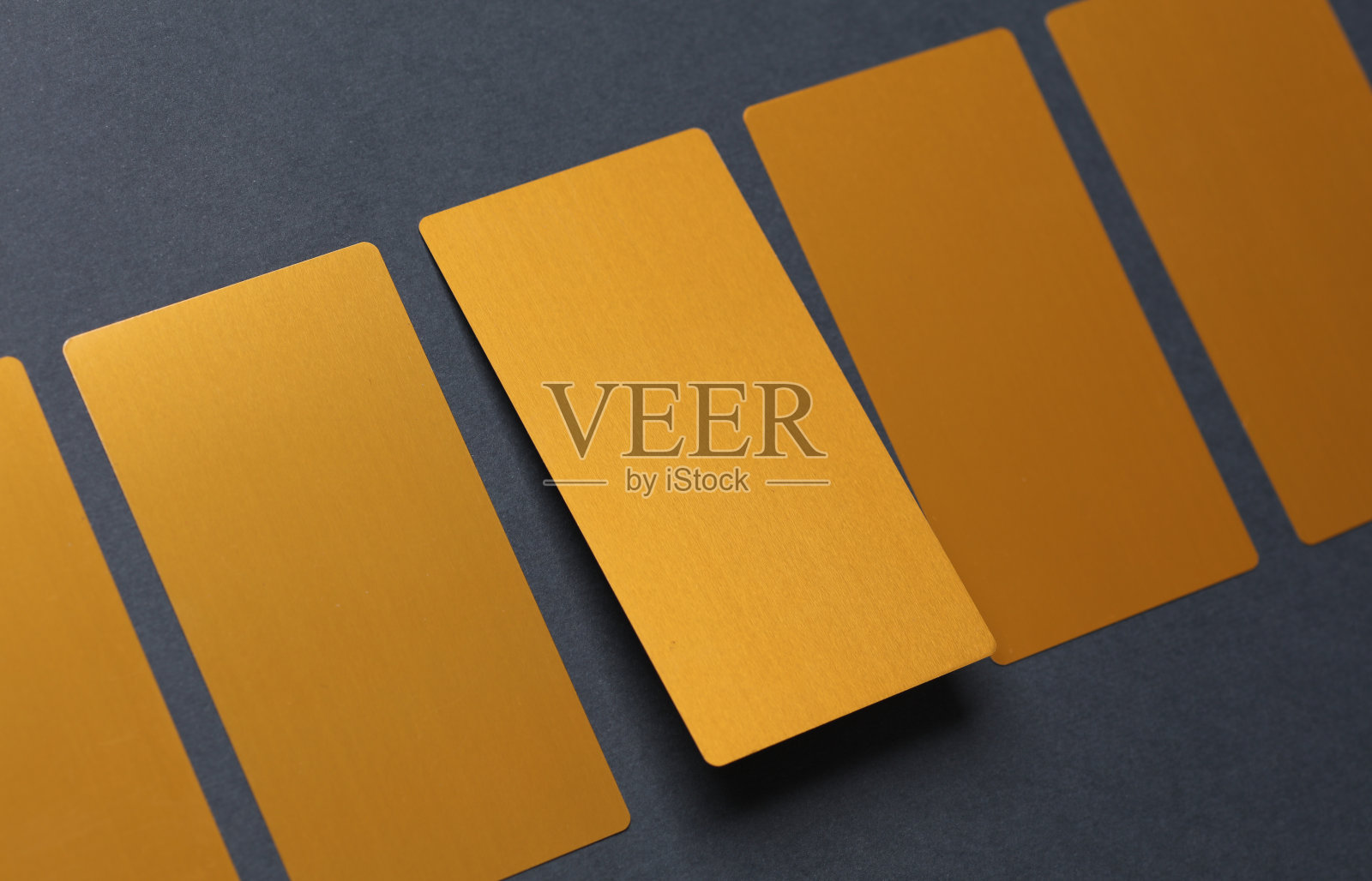 深灰色背景上的金色名片。照片摄影图片