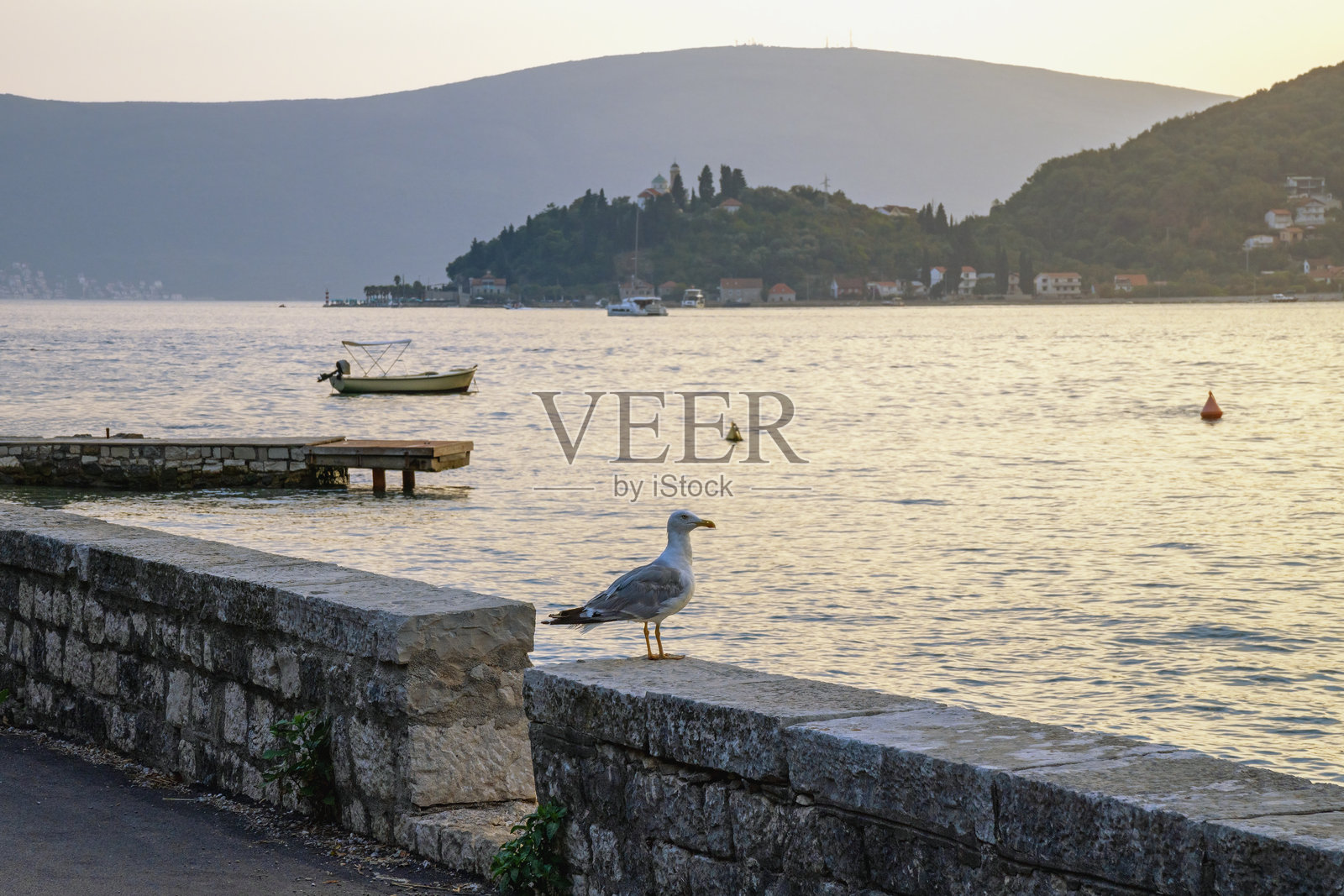 晚上的地中海风景。黑山。远处的科托尔湾和卡梅纳里镇的景色。照片摄影图片