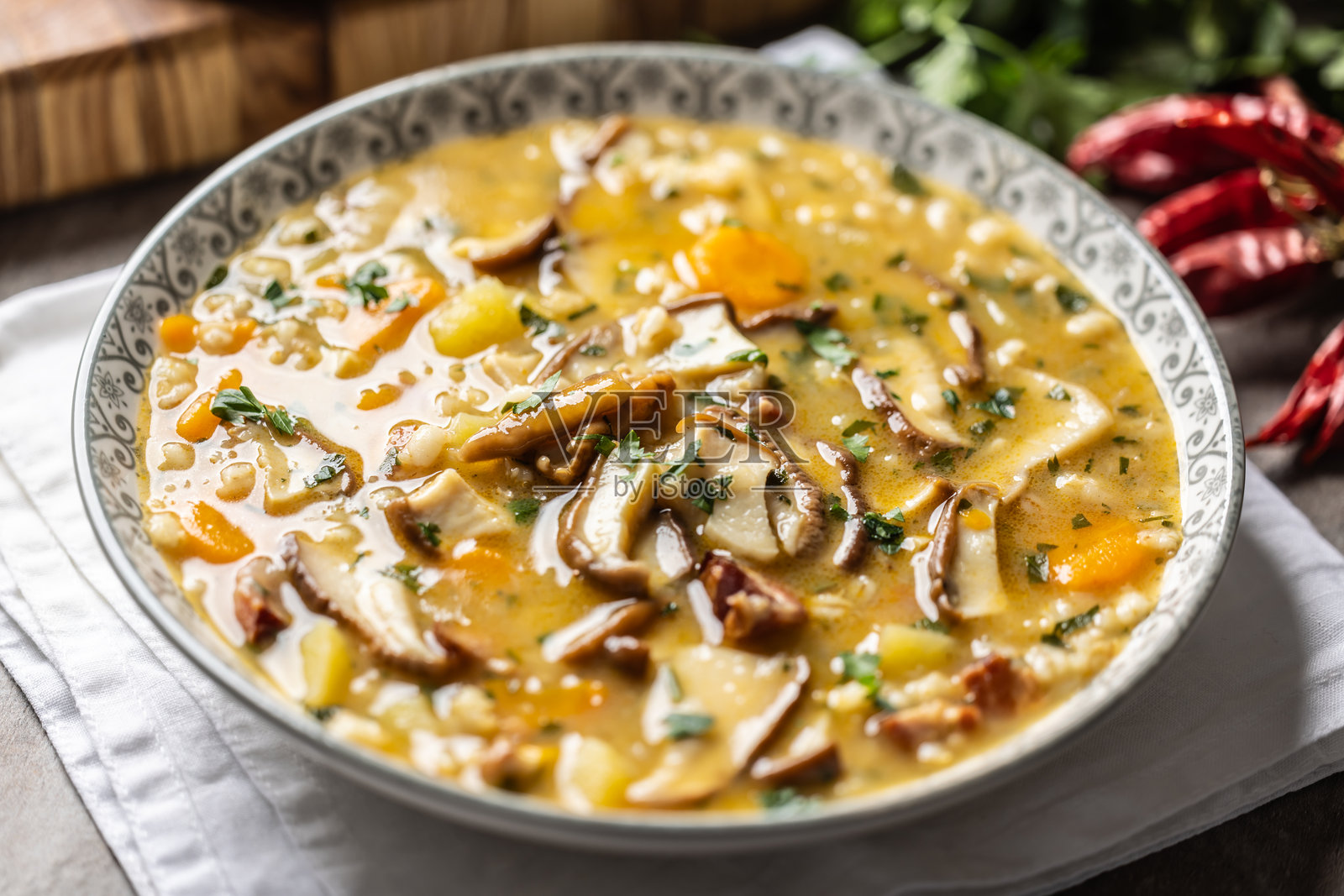 自制美味的汤,采用野生蘑菇、培根、胡萝卜和大麦粒制作。照片摄影图片