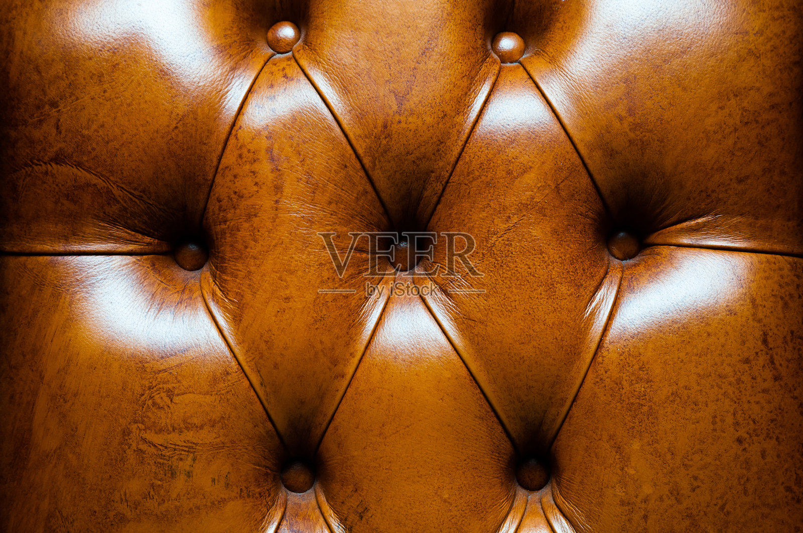 棕色皮革沙发的纹理,带有铆钉。照片摄影图片