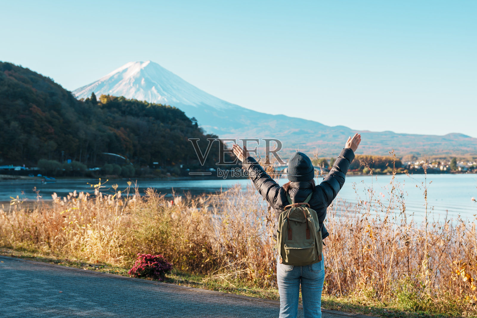 在河口湖的富士山前,快乐的女性游客欣赏风景,游览日本山梨县富士河口湖的富士山。旅游景点的地标。日本旅行、目的地和度假。照片摄影图片