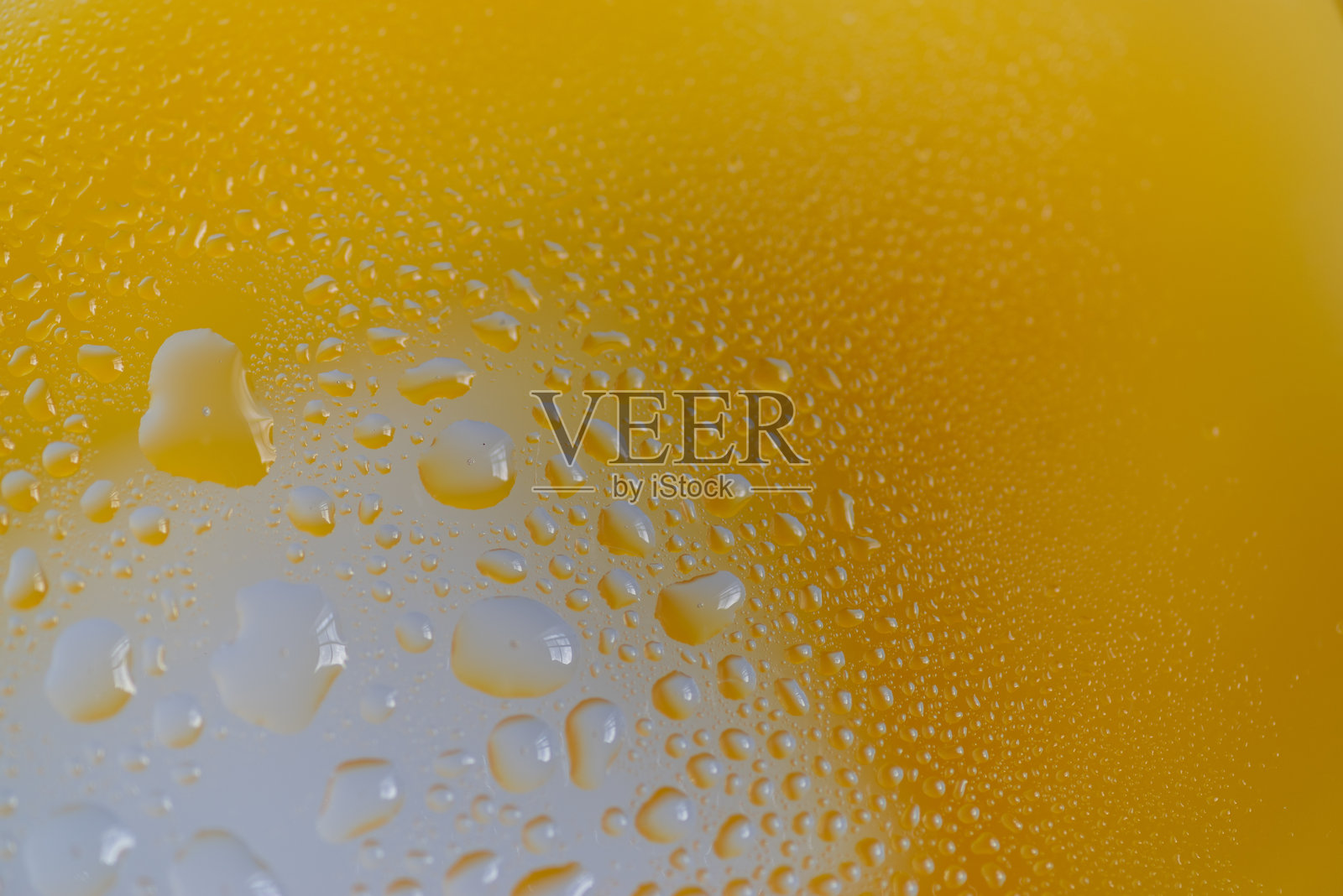 带有黄色背景的玻璃上的水滴照片摄影图片