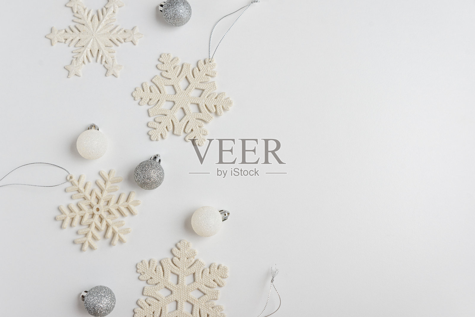 白色圣诞背景,配有雪花和闪亮的装饰品。圣诞节和新年庆祝概念。俯视图照片摄影图片