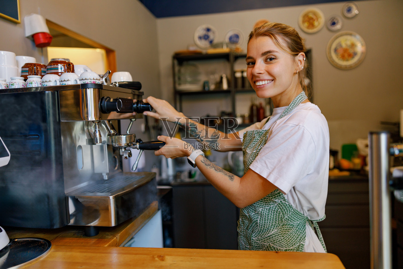一位技艺高超的咖啡师正在温馨的小咖啡馆里精心制作美味的浓缩咖啡。照片摄影图片