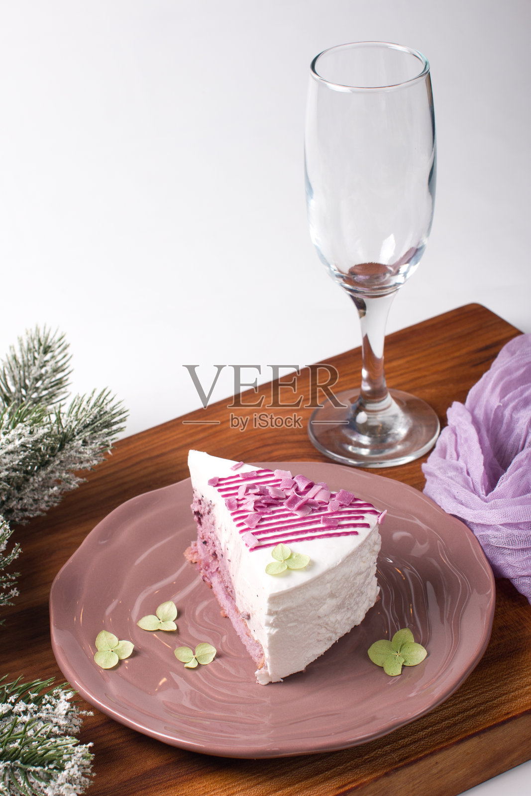 新年甜点摆放在装饰有松枝的木板上。现代酒杯,新年概念照片摄影图片