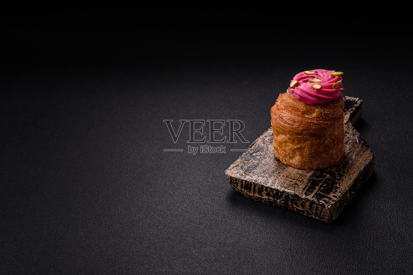 甜美的克拉芬或潘纳托尼,上面装饰有覆盆子和开心果味奶油照片摄影图片