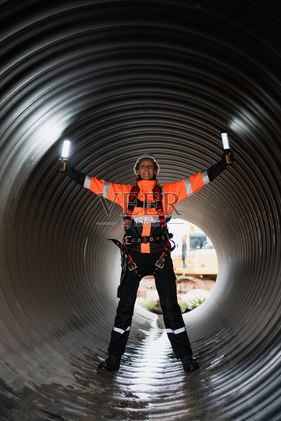工程师在大型钢管内工作,正在为工业设施建设一条运输石油、天然气和燃料的管道。照片摄影图片