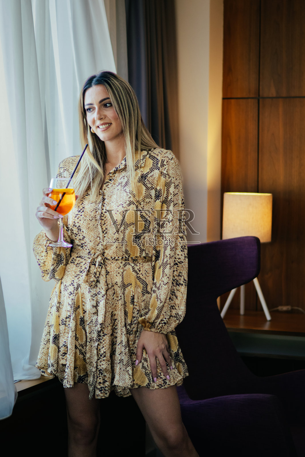 优雅着装的自信金发女商人准备与同事们参加鸡尾酒会。照片摄影图片